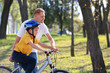© Pixel-Shot - Father teaching his son to ride bicycle outdoors