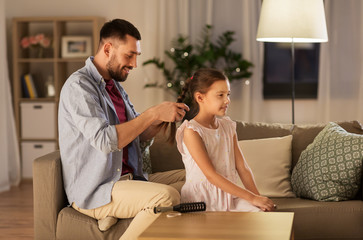 Canvas Print - family and people concept - happy father braiding daughter hair at home