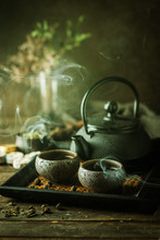 Still-life Of Japanese Healthy Green Tea In A Small Cups And Teapot Over Dark Background