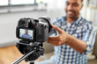 © Syda Productions - blogging, videoblog and equipment concept - close up of smiling indian male video blogger adjusting camera at home