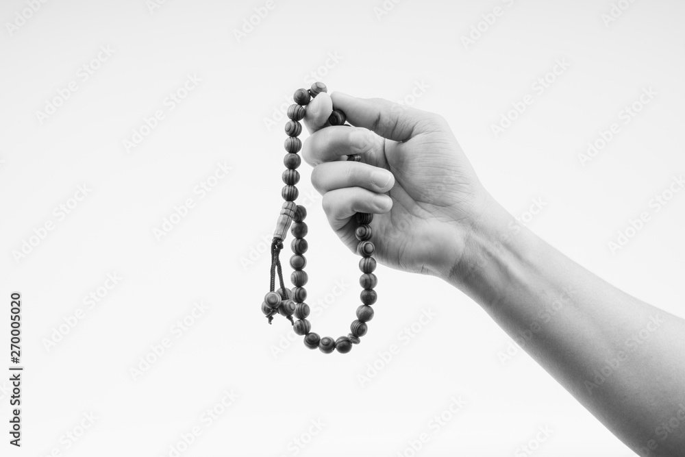 Hand holding a muslim rosary beads or Tasbih on black and white. Copy ...
