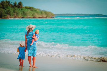 family on beach -mother with two kids at sea