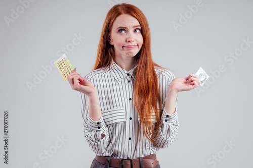 Picture Of Young Redhead Be Lost In Thought Businesswoman In Striped Shirt With One Pack Of Condom And Birth Control Pills Choosing Thinking White Background Studio Stock Photo Adobe Stock