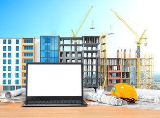 Sticker - Desktop with an open laptop, construction drawings in rolls, construction helmet on the background of construction. 3D illustration