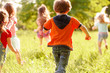 © Andrey - a group of children playing and running in the park on a green gozon.