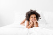 © Lisa Tichané - Cute African American girl with Afro lying on bed