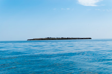 Wall Mural - Sea view with an island in the distance.