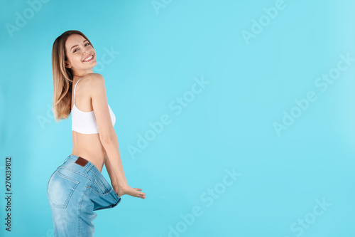 Cuadros en Lienzo Slim woman in oversized jeans on color background, space for text