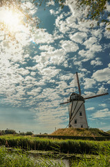 Wall Mural - Old windmill next to canal and sunlight at Damme