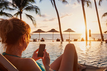 Woman Using Smartphone On Beach Luxury Hotel Near Swimming Pool, Travel App For Tourist On Mobile Phone