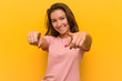 © Asier - Young european woman isolated over yellow background cheerful smiles pointing to front.