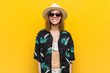 © Asier - Young pretty woman wearing a hawaiian shirt very happy over yellow background.