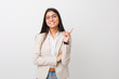 © Asier - Young business arab woman isolated against a white background smiling cheerfully pointing with forefinger away.