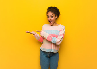 Young black african american girl with blue eyes holding something with hand