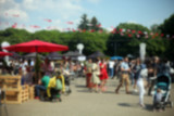 Fototapeta Kosmos - Defocused background of people in park food festival, summer festival, sunny day