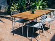 © tete_escape - Wooden dining table with white chairs in the outdoor garden