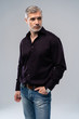 © opolja - Cheerful man of middle age against white background, wearing jeans and black shirt, mid shot.