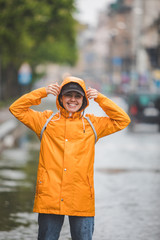 Poster - young pretty smiling woman portrait in raincoat with hood