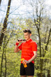 © Olha - The man pose with a tennis racket and orange thermocouple, on the background of green park. Sport concept