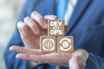 Wall Mural - devops agile software development operations concept on a wooden blocks in a businessman hands.