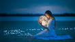 Beautiful attractive girl on a night beach with sand and stars hugs the moon, Artistic Photography