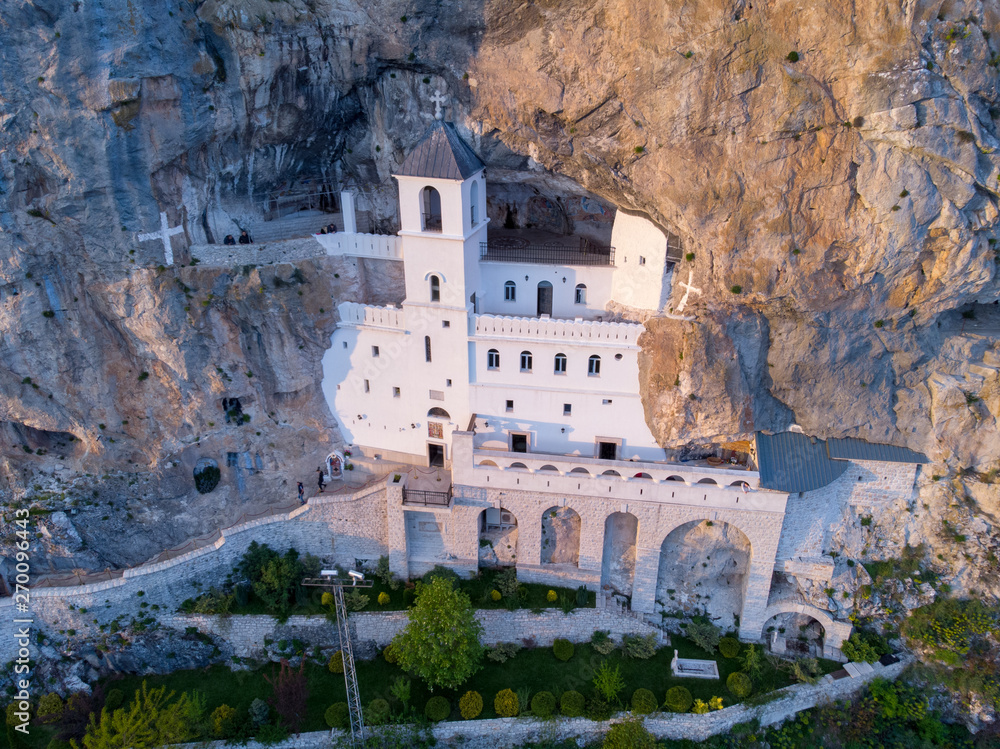 Monastery of Ostrog is a monastery of Serbian Orthodox Church placed against an almost vertical rock of Ostroska Greda, Montenegro, Europe. It is dedicated to Saint Basil of Ostrog. - obrazy, fototapety, plakaty 
