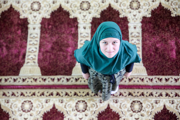 Wall Mural - Young Muslim woman praying,in the mosque