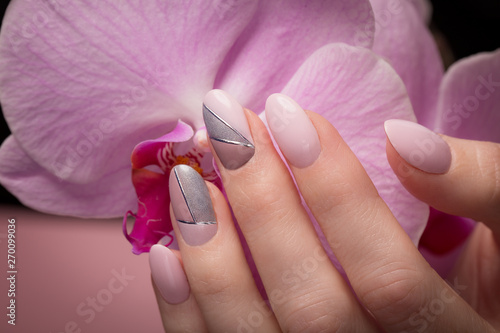 purple-neat-manicure-on-female-hands-on-flowers-background-nail-design