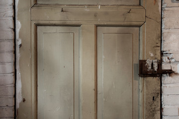 Wall Mural - Old dirty wooden door industrial building dirty, close-up background texture