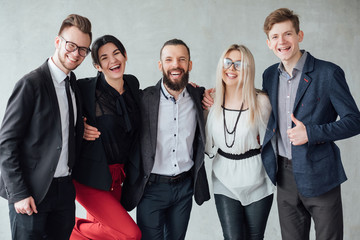 Team building. Social relations. Young cheerful male and female colleagues standing close to each other, smiling.