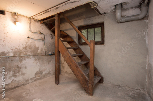 Fotografía empty basement in abandoned old industrial building with little light and a wood