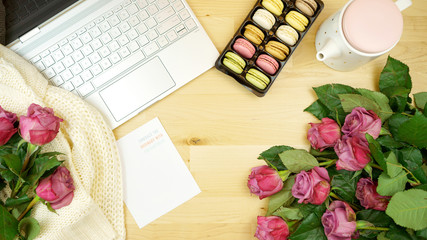 Canvas Print - Feminine desk or workspace coffee break time overhead flatlay with modern hi tech laptop and scattered roses with copy space.