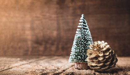 Wall Mural - Christmas tree and gold pine cone on grunge wood table and dark brown wooden wall.Winter Merry Christmas holiday greeting card