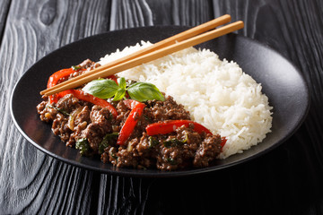 Wall Mural - Traditional Thai Basil Beef, or Pad Gra Prow over white rice closeup on a plate. horizontal