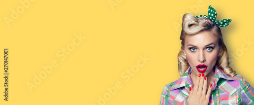 Photographie Photo of young surprised pin up girl with open mouth, against yellow background