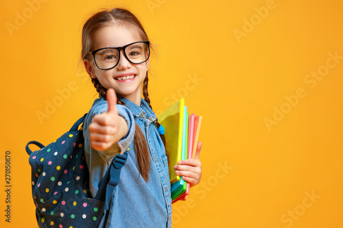 Fotografía funny child school girl girl on yellow background .