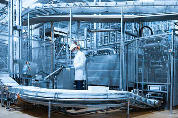 man in a white robe and a cap make an inspection of the production line