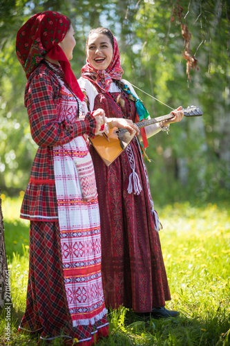 Obrazy folk  dwie-mlode-kobiety-w-tradycyjnych-rosyjskich-strojach-stoja-w-lesie-i-patrza-na-siebie