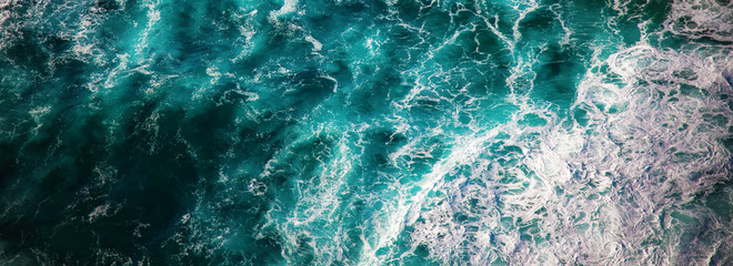 Sea water with foam waves, shot from above abstract natural background and texture