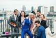 © Halfpoint - A group of joyful businesspeople having a party outdoors on roof terrace in city.