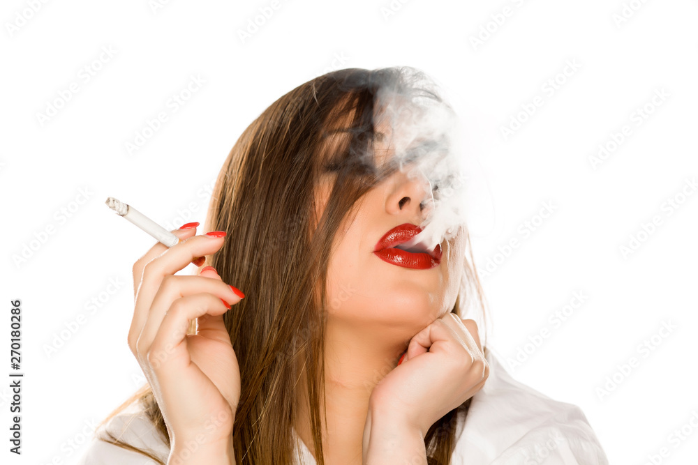Portrait of beautiful woman with makeup and long hair smoking cigarette on  white background Stock Photo