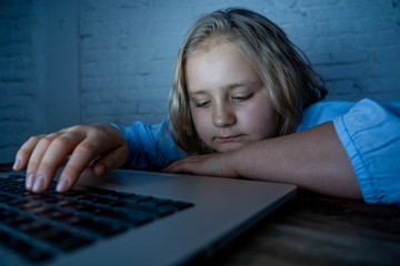 Sad young girl with laptop suffering bullying and harassment online. Cyber bullying victim