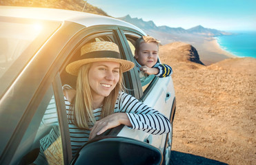 Happiness mother and son, sitting in white car and look on the b