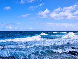 A view of a surfer enjoying the strong waves of Hawaiian ocean.