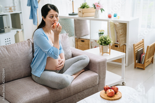 Young Pregnant Asian Woman Holding Red Apple With Plate On Table