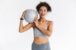 © Drobot Dean - Beautful young amazing sports fitness african woman posing isolated over white background with ball.