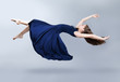 A girl in a blue dress is floating in the air. Dress and hair fluttering in the wind. Flight. Fantasy.
