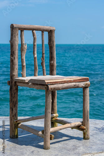 Wooden Chair In Empty Cafe Next To Sea Water In Tropical