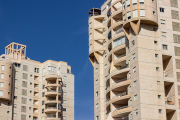 Wall Mural - modern city street high buildings facade with window urban concept photography on vivid blue sky background 