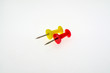 Red and yellow stationery buttons close-up on white background without shadow